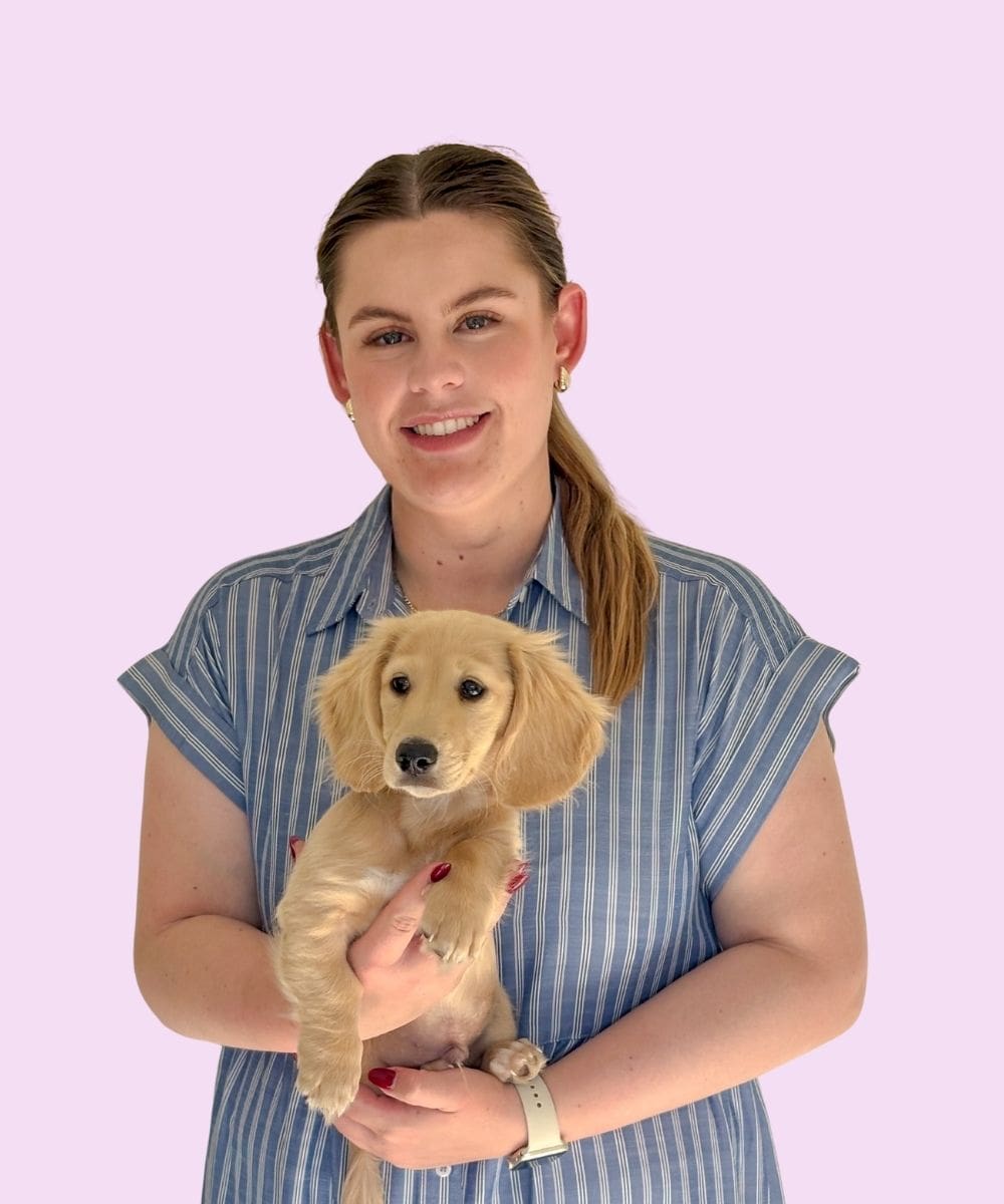 image of Tess smiling and holding a small dog in her arms