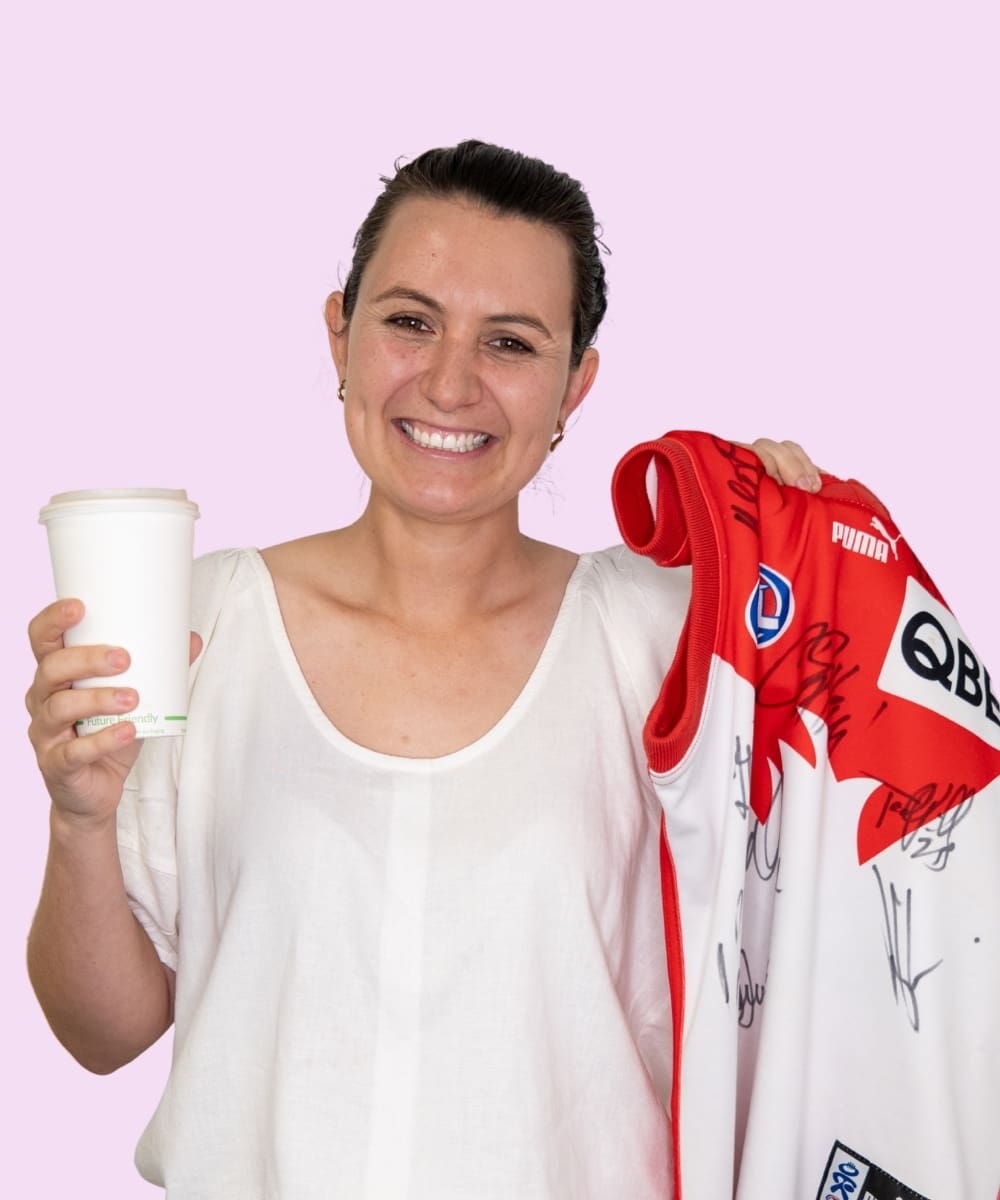 Meg holding a coffee cup and Sydney Swans guernsey